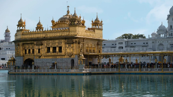 a large golden building sitting next to a body of water